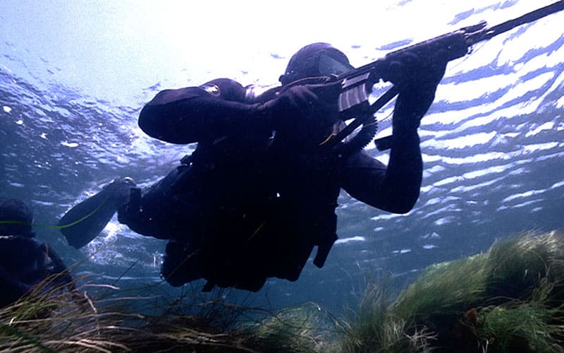 A scuba diver is underwater with his camera.