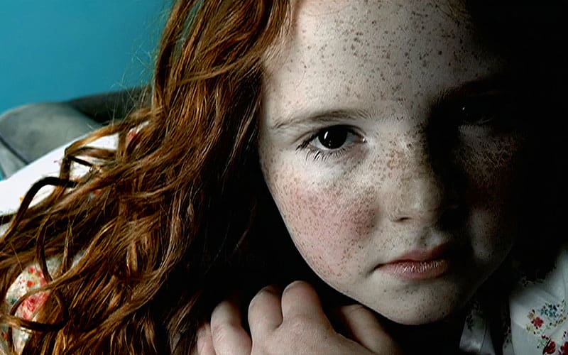 A close up of a child with red hair